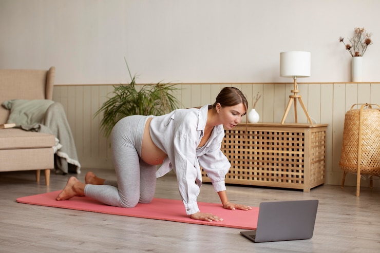 pregnant-woman-practicing-yoga-home_23-2149121122